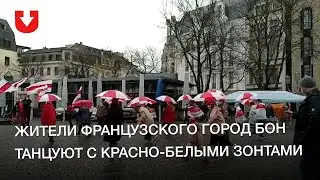 Жители французского город Бон танцуют с красно-белыми зонтами